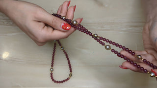 Long necklace with transluscent red-violet beads and gold accents - Artful Accumulator Boutique Vintage
