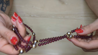 Long necklace with transluscent red-violet beads and gold accents - Artful Accumulator Boutique Vintage