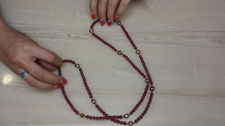 Long necklace with transluscent red-violet beads and gold accents - Artful Accumulator Boutique Vintage