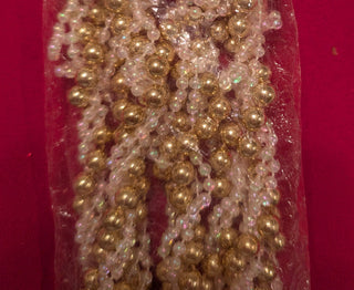 A new gold and white twisted vintage garland, packaged in a clear plastic bag with a red background. The packaging has a Christmas theme with 'Hansen's Christmas Stuff' branding.