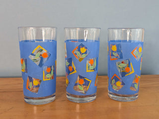 Small tumblers with framed multicolor abstract tulips in a blue background, set of 3