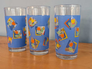 Small tumblers with framed multicolor abstract tulips in a blue background, set of 3