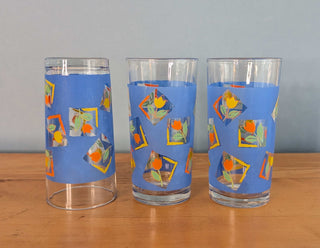 Small tumblers with framed multicolor abstract tulips in a blue background, set of 3