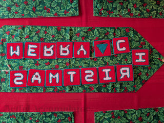 "Merry Christmas" Plastic Canvas Banner with green, red, and white stitched yarn