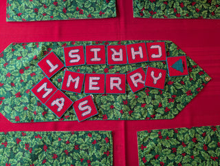 "Merry Christmas" Plastic Canvas Banner with green, red, and white stitched yarn