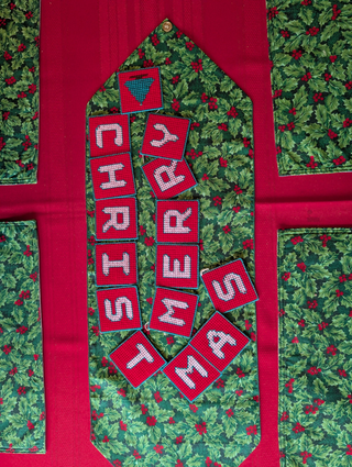 "Merry Christmas" Plastic Canvas Banner with green, red, and white stitched yarn