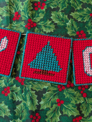 "Merry Christmas" Plastic Canvas Banner with green, red, and white stitched yarn