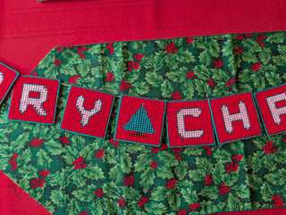 "Merry Christmas" Plastic Canvas Banner with green, red, and white stitched yarn
