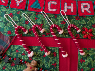 Decorative Christmas candy canes with gingerbread men on a festive background.