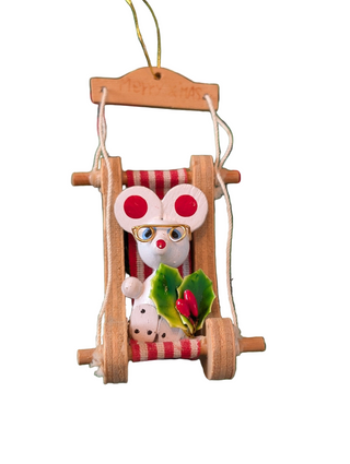 Decorative mouse in a striped red and white wooden sled with a on white background