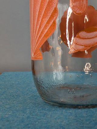 Seashells on a glass storage jar with orange plastic lid - Artful Accumulator Boutique Vintage