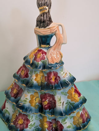 GIOVANNI GIRARDI 1950's figure of a beautiful woman wearing a tiered floral gown in blue, pink, and gold, a light orange sash, and a hand mirror