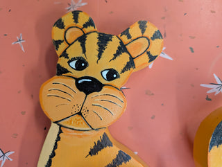 adorable orange cartoon tiger with black stripes on wood, signed on the back