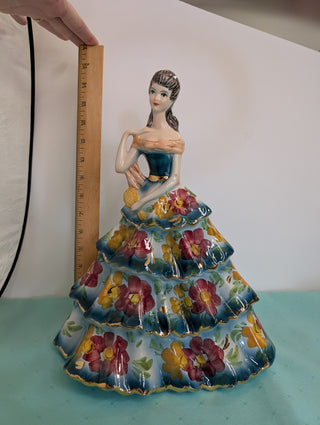 GIOVANNI GIRARDI 1950's figure of a beautiful woman wearing a tiered floral gown in blue, pink, and gold, a light orange sash, and a hand mirror