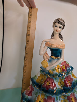 GIOVANNI GIRARDI 1950's figure of a beautiful woman wearing a tiered floral gown in blue, pink, and gold, a light orange sash, and a hand mirror
