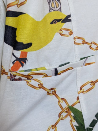 Modern * white zip up cardigan with imagery of jewels, gold chains, and yellow birds