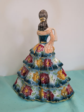 GIOVANNI GIRARDI 1950's figure of a beautiful woman wearing a tiered floral gown in blue, pink, and gold, a light orange sash, and a hand mirror
