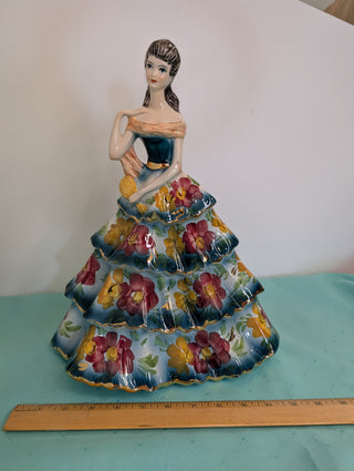 GIOVANNI GIRARDI 1950's figure of a beautiful woman wearing a tiered floral gown in blue, pink, and gold, a light orange sash, and a hand mirror